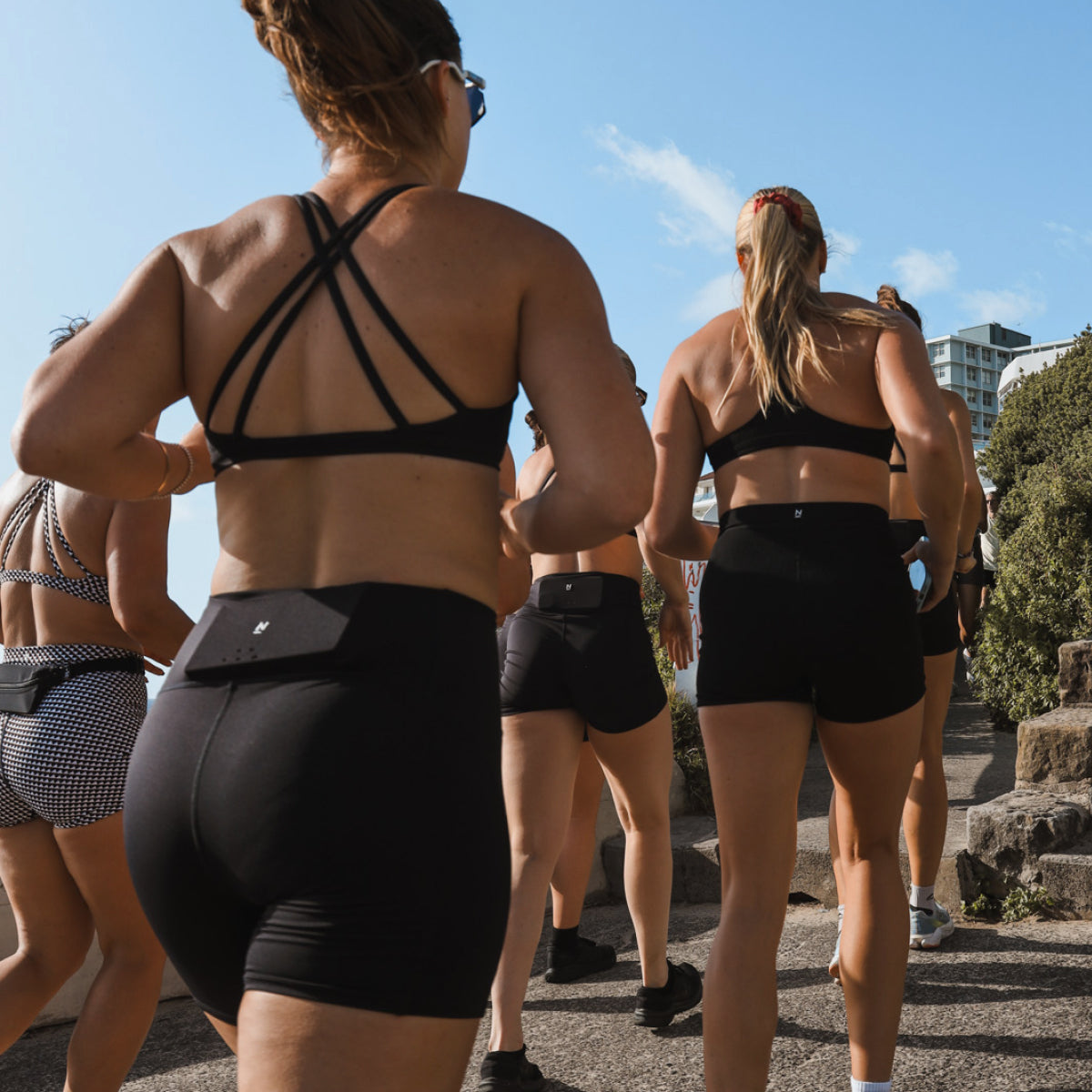 Group of women running in shorts and crop tops