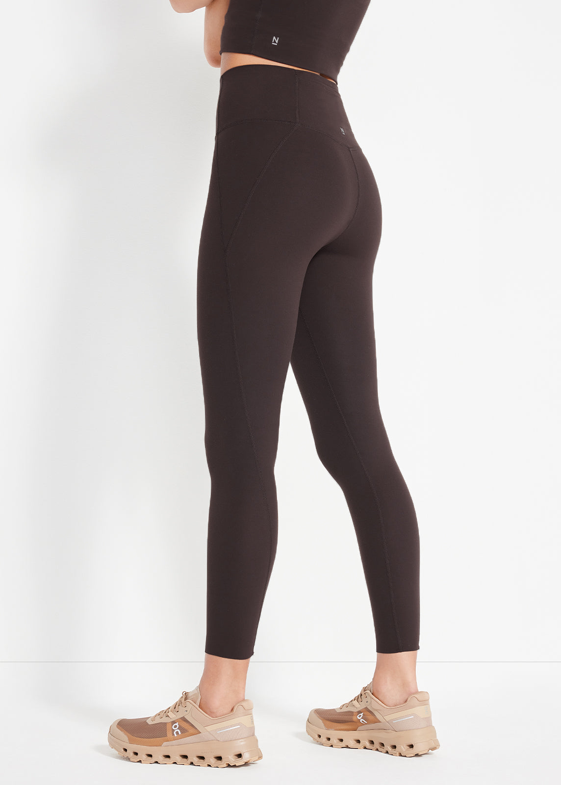 Back angle of chocolate leggings highlighting sculpted seams and ankle-length fit
